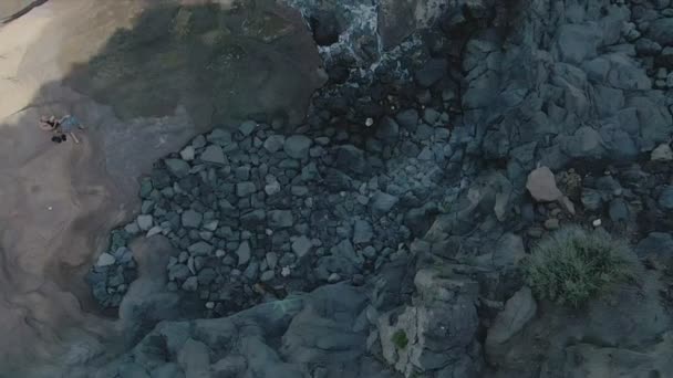 Верхний снимок скалистого вулканического побережья с чистым морем — стоковое видео