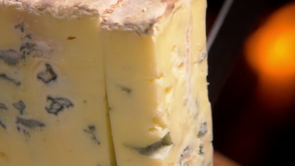 Kawałek niebieskiego sera Roquefort spada na drewnianą deskę — Wideo stockowe
