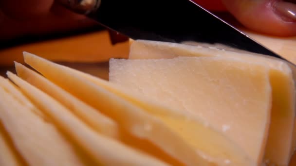 Жесткий сыр пармезан, разрезанный ножом на тонкие ломтики — стоковое видео