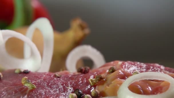 Uienringen vallen in slow motion op het rauwe vlees — Stockvideo