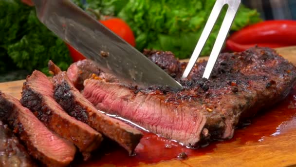 Приготований м'ясний стейк нарізаний ножем на дошці — стокове відео