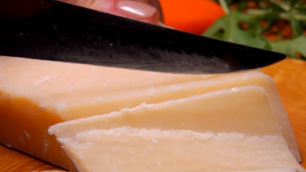 Mes snijdt een harde Parmezaanse kaas in dunne plakjes — Stockvideo