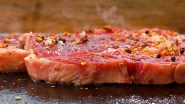 Carne espolvoreada con pimienta y especias se fríe en la parrilla de piedra — Vídeos de Stock