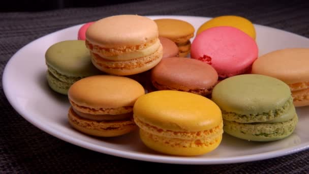 Macaron di mandorle francesi multicolori si trovano su una piastra bianca — Video Stock