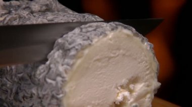 Close up of a Sainte maure de Touraine goat cheese with straw in the middle