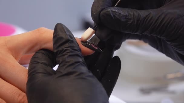 Close up of a manicurists hands decorating stylish manicured nails — Stockvideo