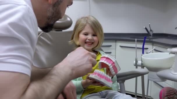 Dentista mostra um como limpar os dentes com uma escova de dentes — Vídeo de Stock