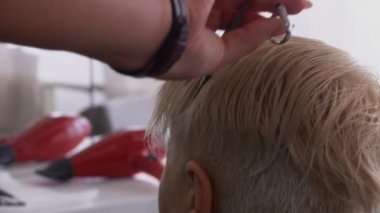 Rear close up view of hands with scissors and comb in the hands