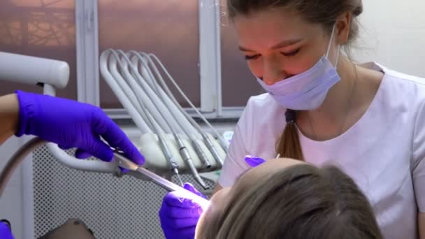 Женщина дантист делает профессиональную стоматологическую чистку для пациента — стоковое видео