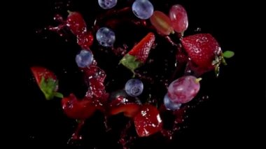 Various fruits are flying with splashes of juice on the black background