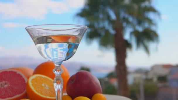 Un'oliva verde sta cadendo in un bicchiere con vermuth Martini — Video Stock