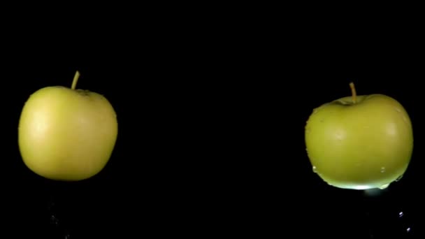 Два зеленых яблока сталкиваются друг с другом, поднимаясь брызги воды — стоковое видео