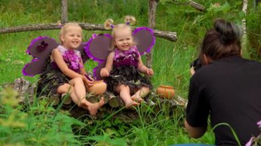 Female photographer takes pictures of beautiful girls playing violet butterflies