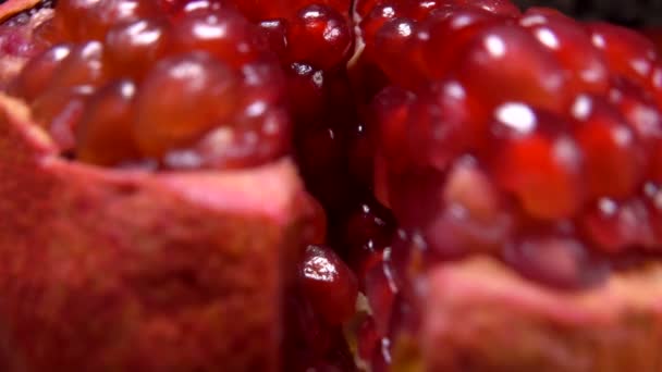 Reifer roter Granatapfel wird mit saftigen Kernen in vier Stücke zerkleinert — Stockvideo