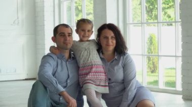 Fotoğrafçı, gülümseyen tatlı bir kızı olan bir ailenin fotoğraflarını çekiyor.