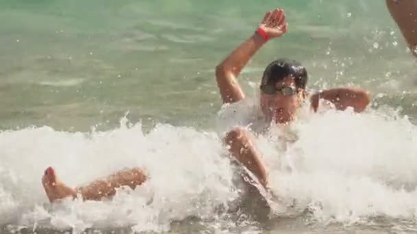 Hoge golven van de zee surf cover jongen in een zwembril — Stockvideo