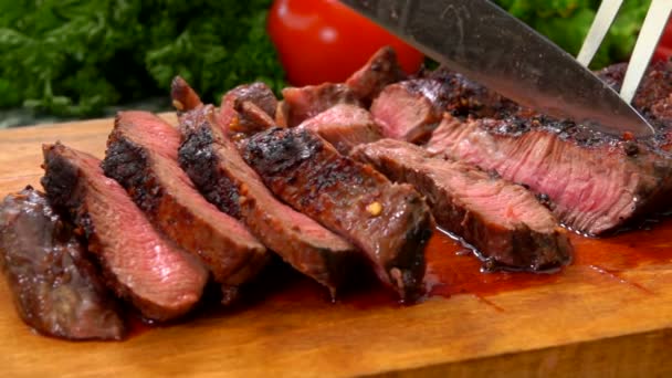 Připravený hovězí steak krájený na plátky nožem na dřevěné desce — Stock video