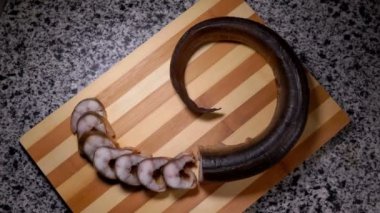 Top view of smoked eel slices lying on a cutting board 