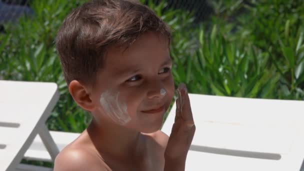 Kleine jongen besmeurd met zonnebrandcrème — Stockvideo