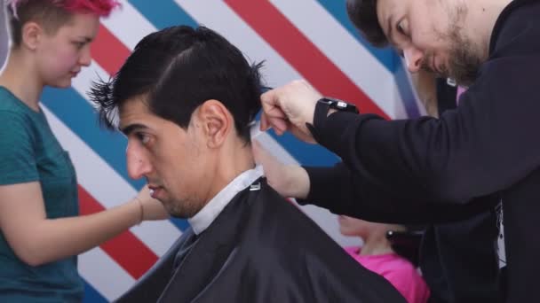 Barbudo hombre está entrenando para hacer un corte de pelo masculino bajo la supervisión — Vídeos de Stock