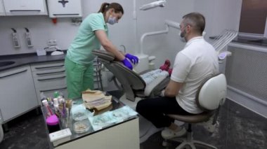 Hemşire dişçi muayenesi için küçük tatlı bir kız hazırlıyor.