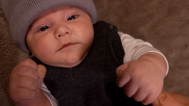 Pequeno bebê de olhos pretos adorável está olhando com curiosidade para a câmera — Vídeo de Stock