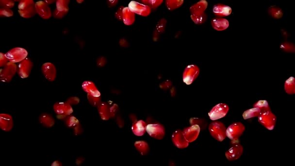 Ripe pomegranate grains are bouncing on the black background — Stock Video