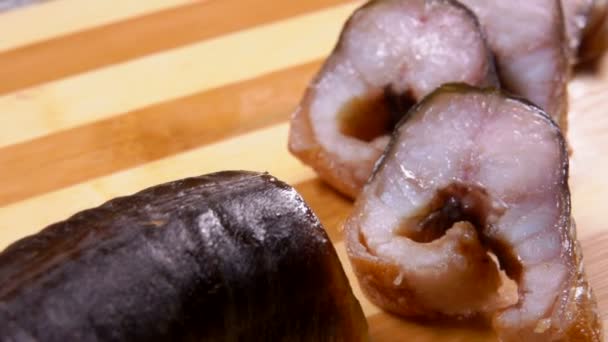 竹のまな板の上に横たわるおいしい燻製ウナギのスライス — ストック動画