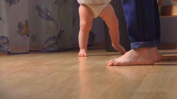 Moeder helpt haar schattige baby om de eerste stappen te zetten — Stockvideo