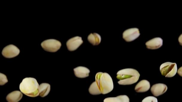 Pistachos frescos vuelan sobre un fondo negro — Vídeos de Stock