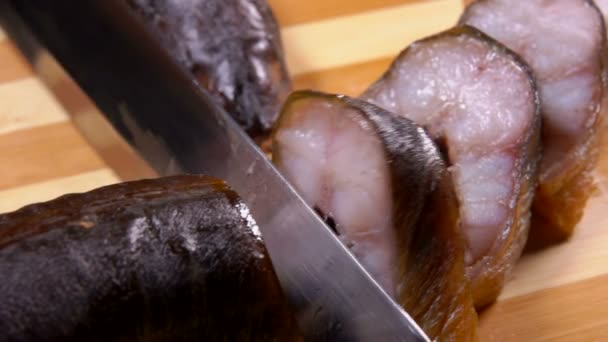 Närbild av en kniv som skär läcker rökt ål i skivor — Stockvideo