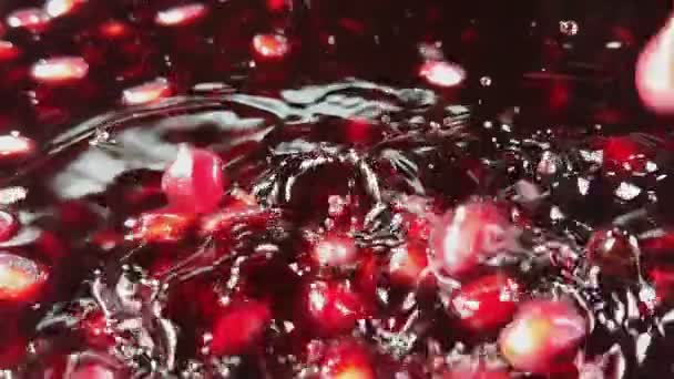 Červená zralá zrnka granátového jablka padají do šťávy — Stock video