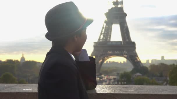 A fiú beszél telefonon az Eiffel-torony hátterében hajnalban. — Stock videók