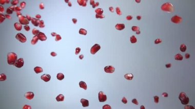 Sulu olgun nar taneleri çapraz olarak su damlalarıyla düşüyor.