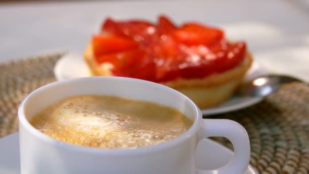 Suiker kubus valt in espresso koffie in een witte beker — Stockvideo