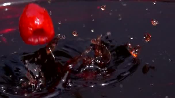 Rijpe frambozen vallen in sap met spatten in trage motoïne — Stockvideo