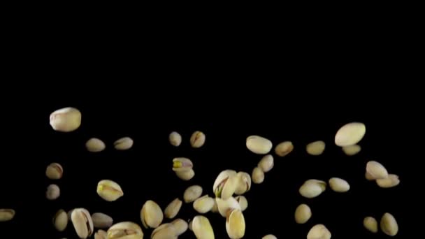 Fresh green pistachios are bounce on a black background — Stock Video