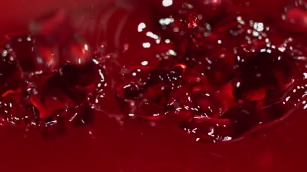 Νόστιμα σπόρια ροδιού πέφτουν στον κόκκινο χυμό με πιτσιλιές. — Αρχείο Βίντεο