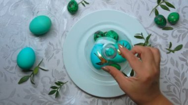 Eller, beyaz tabaktan yeşil paskalya yumurtaları taşıyan cam bir kubbeyi alır.