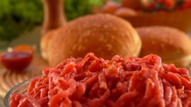 Bitki ve baharat karışımı cam kasedeki kıyma ete dökülüyor.