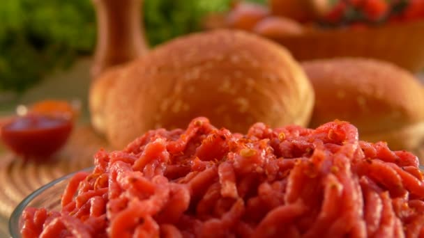Mieszanka ziół i przypraw spada na mielone mięso w szklanej misce — Wideo stockowe