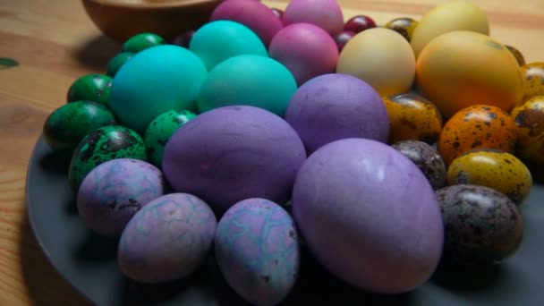 Крупный план разноцветного пасхального цыпленка и перепелиных яиц на серой тарелке — стоковое видео