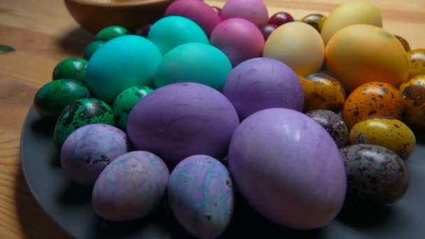 Großaufnahme von bunten Osterhühnern und Wachteleiern auf dem grauen Teller — Stockvideo