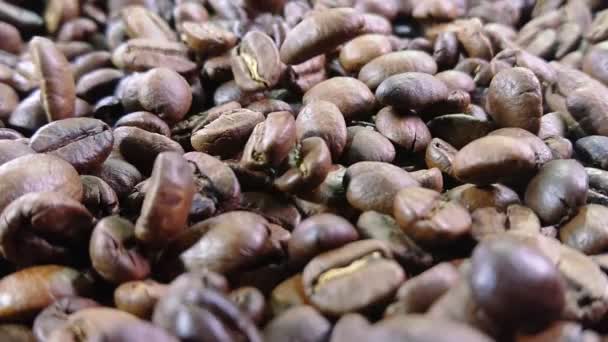 Close-up of roasted coffee beans are falling and spinning in slow motion