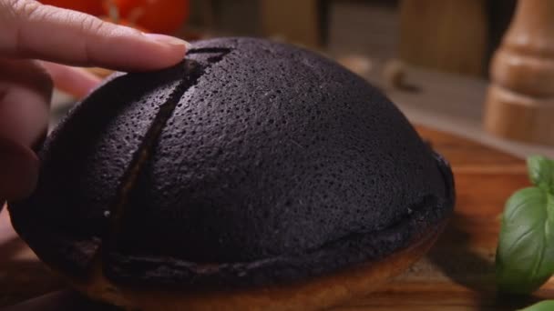 El cuchillo corta un pastel de queso cottage negro Tourteaux Jahan en una tabla de madera — Vídeo de stock