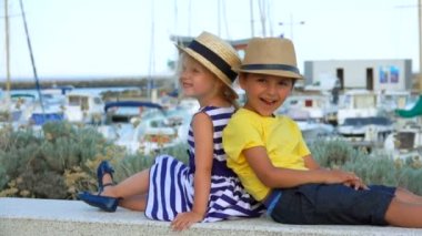 Küçük çocuk ve saman şapkalı sevimli sarışın kız öpüşüyorlar.