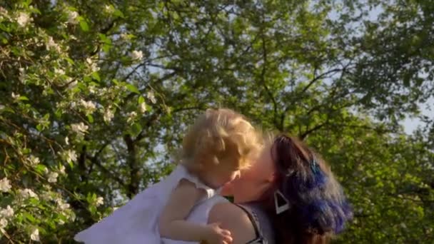 Annem kusuyor ve beyaz elbiseli sevimli kızını öpüyor. — Stok video