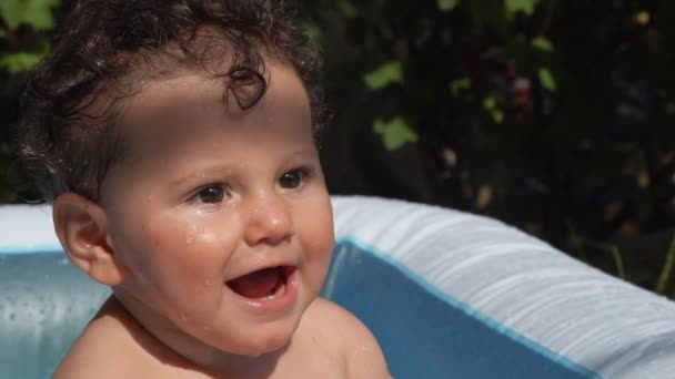 小卷曲湿孩子在后院里的充气游泳池里洗澡 — 图库视频影像