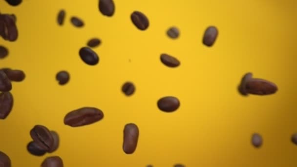 Chicchi di caffè torrefatto Arabica stanno volando e ruotando sullo sfondo giallo — Video Stock