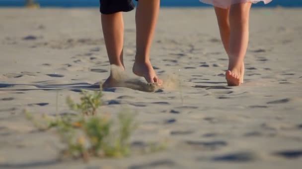 Disparo en ángulo bajo de las piernas de los niños que caminan en la playa a la cámara — Vídeos de Stock